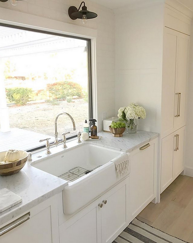 Farmhouse sink with vintage barn sconce above kitchen window #Farmhousesink #vintagebarnsconce #kitchenwindow