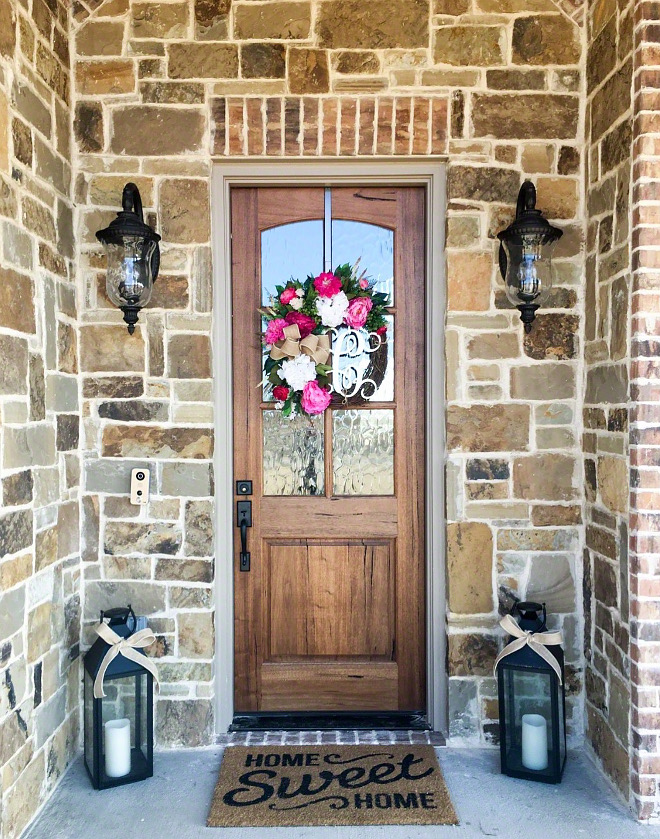 Farmhouse Stone exterior with wood door and brick accent The exterior stone is Oklahoma Chopped