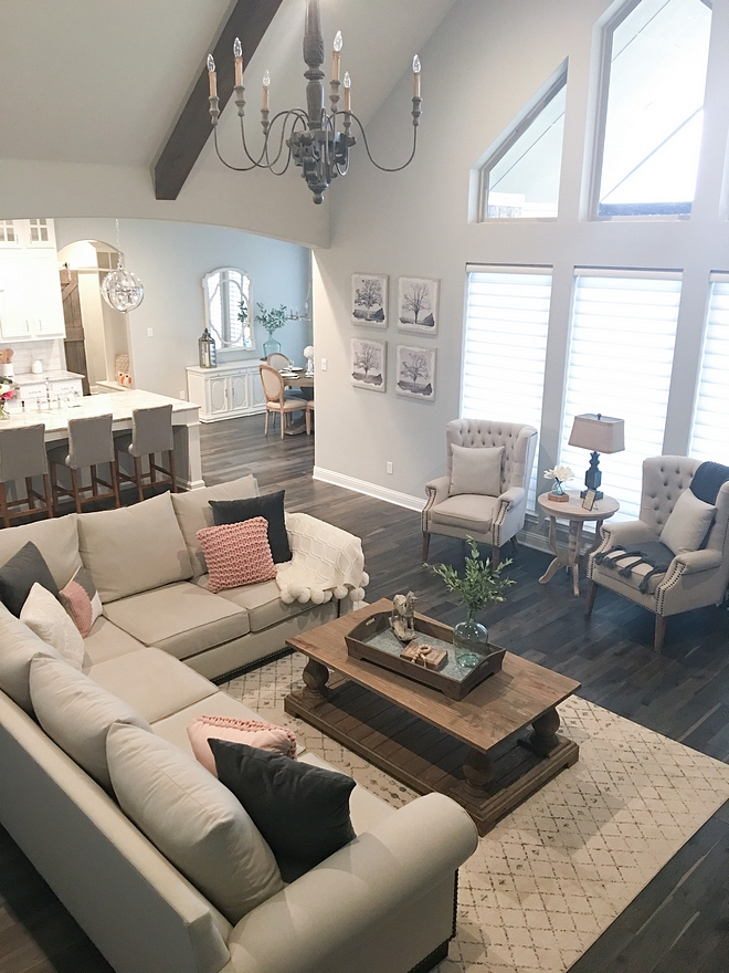 Farmhouse Living Room Vaulted Ceiling with Beams and French Chandelier Paint Color Sherwin Williams Repose Gray SW 7015 Wall Color Sources on Home Bunch #Farmhouselivingroom #Farmhouse #livingroom #vaultedceiling #beamceiling #beamvaultedceiling