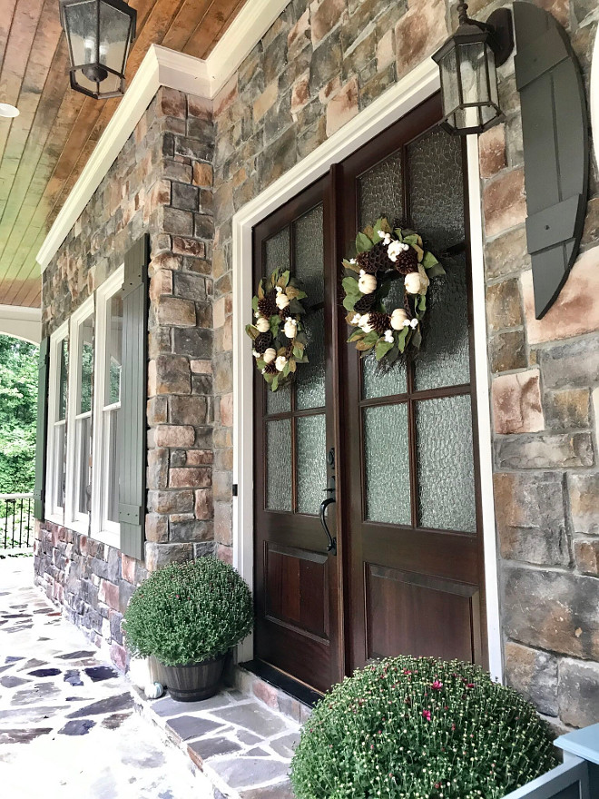 Stone exterior porch with double wood and glass front door sources on Home Bunch