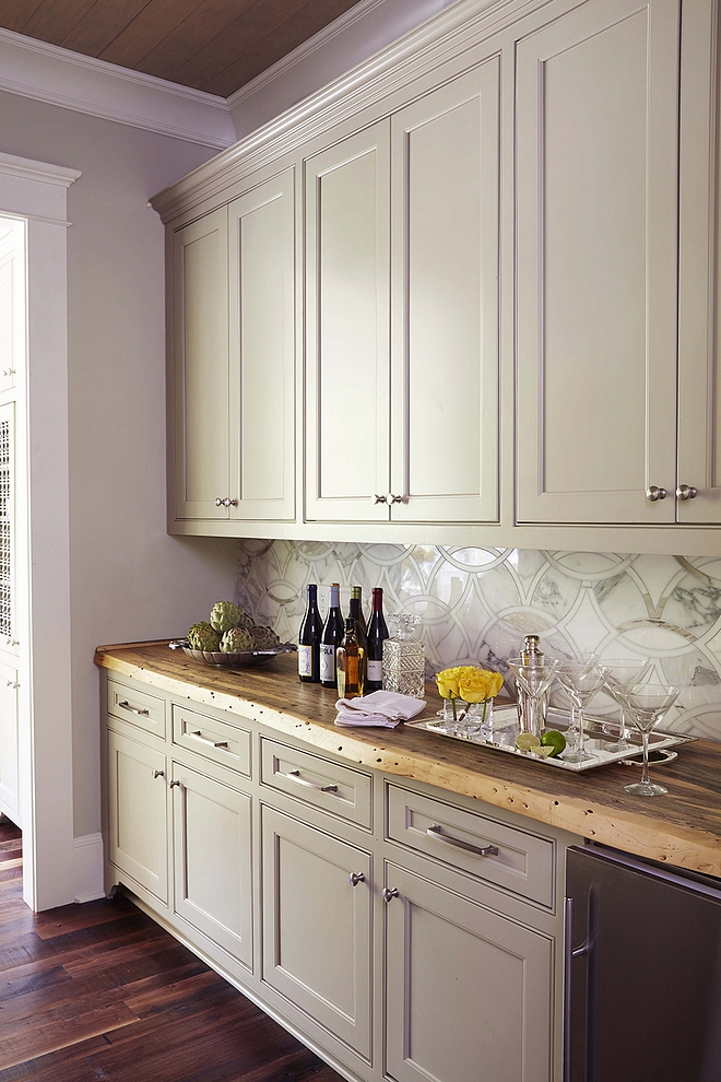 This stunning butler's pantry features grey cabinets, painted in Senora Gray by Benjamin Moore and live edge countertop. Backsplash is the same used in the kitchen